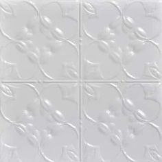 four square white tiles with flowers and leaves on the bottom, one is made out of ceramic