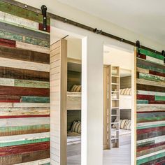 an open sliding door with multicolored wood planks on the outside and inside