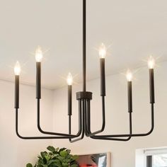 a black chandelier with five candles hanging from it's centerpieces