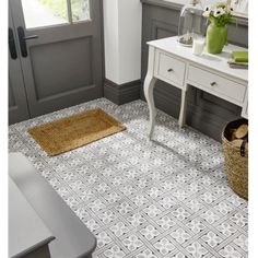 a bathroom with gray and white tile flooring next to a desk, chair and mirror