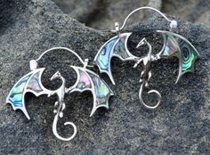 the earrings are made out of silver and abaphant glass, with swirly designs on them