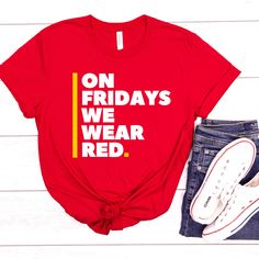 a t - shirt that says on friday's we wear red next to a pair of jeans