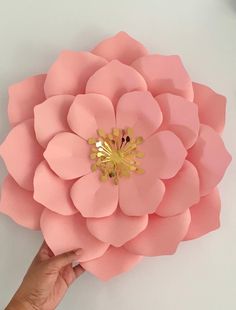 a person holding up a paper flower