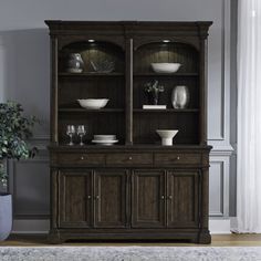 a dark brown china cabinet with glass doors