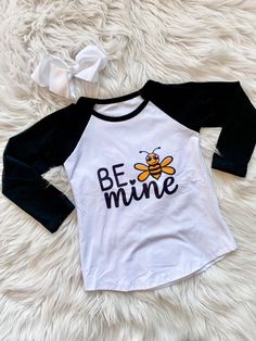 These Bee Mine Raglans are long sleeved black and shite shirts with "Be Mine" and a cute little bumble bee on the front. Perfect for Valentine's Day! Adult shirt Only. Children's sizes are currently out of stock. Includes: Child or adult raglan shirt only Fit: True to size Long Sleeve Cotton Shirt With Character Print, Fun Long Sleeve Cotton Shirt, Cute Long Sleeve Shirt With Cartoon Print, Spring Long Sleeve T-shirt With Character Print, Black Long Sleeve Top With Character Print, Black Long Sleeve Shirt With Character Print, Playful Black Cotton Shirt, Cute Black Tops With Letter Print, Cute Black Crew Neck Shirt