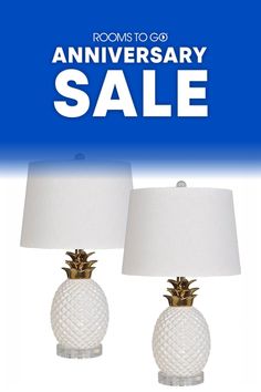 two white pineapple lamps with the words room to go anniversary sale written on them