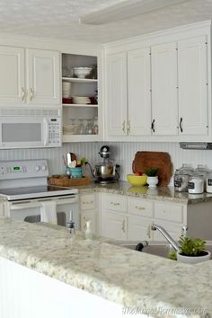 a kitchen with white cabinets and granite counter tops