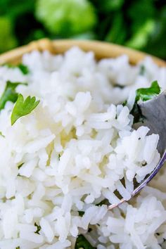 white rice in a wooden bowl with a spoon