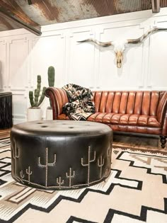 a living room filled with furniture and a cow skull on the wall