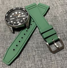 Premium Natural FKM Rubber Blend Watch Strap - Military Green 20/22mm - Swiss Aviation design Colour of this strap is Matte Military Green. All hardware is 316L brushed Stainless steel with quick release spring bars. These straps are created from a premium Natural / FKM Rubber blend and suitable for your luxury Swiss sports and aviation time pieces. This rubber blend is a premium material providing the user comfort and durability. This rubber is soft and durable but hard wearing, dust resistant, Green Wear-resistant Watch With Round Dial, Green Round Dial Watch, Green Adjustable Bracelet Strap Watch Accessories, Adjustable Green Bracelet Strap Watch Accessories, Green Watch Accessories With Bracelet Strap As Gift, Green Bracelet Strap Watch Accessories As Gift, Adjustable Durable Green Watch Bands, Aviation Design, Fancy Watches