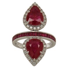 This exclusive ruby and diamond ring was made with the finest quality materials, to ensure that it is both elegant and durable. This beautiful stone set in 18K white gold showcases with two pear cut natural untreated ruby of the finest quality. Set with 0.46 carats of white round diamonds, this exquisite ring is sure to add elegance to any occasion. It weighs 6.95 grams and has a total gem weight of 5.09 carats for a stunning play on color and shape! It's truly a masterpiece of luxury that every Coffin Ring, Ruby And Diamond Ring, Ruby Diamond Rings, Jeweled Earrings, Things Under A Microscope, Modern Ring, Ruby Diamond, Quality Diamonds, Stone Settings