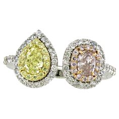 This Toi-et-Moi ring features a captivating dual-center design, where two distinct gemstones take center stage. The first centerpiece is a brilliant pear-shaped yellow diamond, weighing 0.3 carats. The pear-shaped cut exudes grace and timelessness, while the vibrant yellow hue symbolizes warmth and joy. Encircling the yellow diamond are 15 smaller round yellow diamonds, each weighing 0.06 carats. The second centerpiece is an enchanting pink oval diamond, weighing 0.25 carats. The oval cut represents uniqueness and individuality, making it a perfect complement to the pear-shaped yellow diamond. Surrounding the pink oval diamond are 14 round pink diamonds, each weighing 0.07 carats. Adding further allure to this exquisite ring are 49 round white diamonds, with a total weight of 0.39 carats. Pink Diamonds, Yellow Diamonds, Yellow And Pink, 3 Carat, Center Stage, Yellow Diamond, Pink Diamond, Oval Diamond, White Diamonds