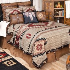 a bedroom with a bed covered in a quilt and pillows