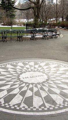 an image of a mosaic design in the middle of a park with benches and trees