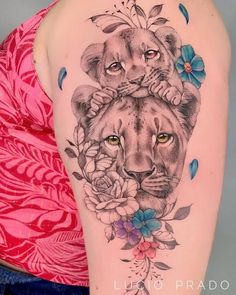 a woman with a tattoo on her arm and a lion in the middle, surrounded by flowers