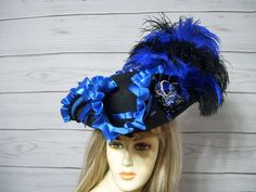 Black woolen pirate hat/tricorn with black and royal blue ostrich feathers, large royal blue satin ruffle, black pleated trim, black satin cocarde with a jewel center and two royal blue satin bows. This hat is 22.5" for the inside circumference. if this is too big for you let me know and I will include a free peel and stick hat sizer to your order. I cannot make the circumference bigger so please keep that in mind. Check out my other pirate hats and other goodies in my etsy shop. Thank you for stopping by. Have a great day. International buyers are responsible for custom fees as it is not included in the shipping. Please Click on the shipping tab to calculate shipping so there are no surprises over shipping.    ALL SALES ARE FINAL!!! NO EXCHANGES! NO REFUNDS! ASK QUESTIONS AHEAD OF TIME AS Tricorn Hat, Pirate Hat, Steampunk Hat, Satin Noir, Pirate Hats, Fancy Hats, Jack Sparrow, Ostrich Feathers, Blue Hat