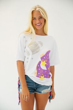 This COWGIRL KICKOFF TEE is perfect for any gameday. Crafted with a white tee, a football patch, and star patches, it's finished off with a vibrant purple cowgirl boots print. Show off your western spirit with this stylish and unique tee. All orders are currently shipping within 14 business days. To receive item quicker, expedited shipping is available at checkout. Cowgirl T Shirt, Cowgirl Graphic, Cowgirl Tshirt Designs, Disco Cowgirl Party T-shirts & Tank Tops, Cowgirl Graphic Tees, Boot Print, Cowgirl Boots, Purple