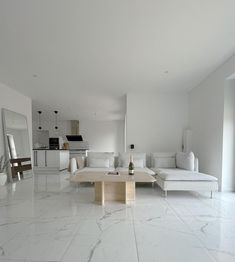 a living room with white furniture and marble flooring in front of a large window