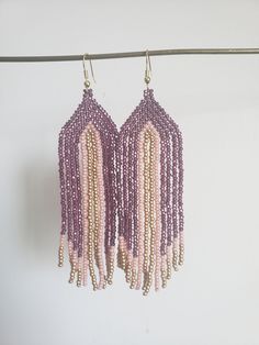 Handwoven beaded earrings. Shiney purple, soft pink and muted gold make these earrings stand out. Work appropriate and yet at the same time can be worn for a night on the town.  What more can you ask for. Made with nickel free findings.  Just under 4 inches long, from top bead to last dangle. approx. 1.5 inches wide Purple Jewelry With Beaded Fringe And Round Beads, Purple Dangle Earrings With Tiny Beads, Purple Beaded Fringe Earrings As Gift, Purple Beaded Dangle Earrings With Tiny Beads, Handmade Lavender Beaded Earrings For Gift, Unique Pink Beaded Dangle Earrings, Unique Pink Dangle Beaded Earrings, Unique Purple Earrings With Dangling Beads, Handmade Purple Beaded Drop Earrings