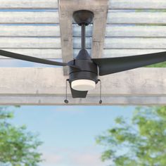 an outdoor ceiling fan mounted on the side of a building with trees in the background