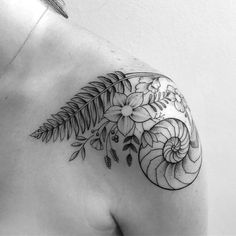 a woman's shoulder with flowers and leaves on it