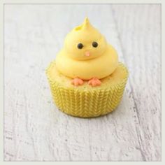 a yellow cupcake sitting on top of a white table