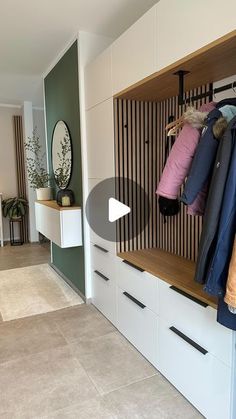 a closet with clothes hanging on the wall, and two drawers in front of it