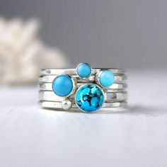 Blue turquoise and silver stacking rings. Created from four different sizes and shades of blue. The largest stone is 6mm in diameter. The other three are complimentary shades of blue and a single silver dot ring. Artfully simple if worn one at a time, they can also be worn with your other stacking rings for a pop of color. Please choose your preferred stone combination from the menu. The last Picture shows the stone combinations I have in stock.  Bright satin finish. Also available in oxidized finish (example shown in the 2nd to last picture). If you'd like your rings oxidized, leave me a note when you check out. Details: 1 - 6mm turquoise cabochon with matrix, 2.2mm hammered silver band; 1 - 5mm turquoise cabochon, 1.7mm band; 1 - 4mm turquoise cabochon, 1.7mm band; 1 - 3mm turquoise cabo Stackable Turquoise Round Jewelry, Bohemian Stackable Blue Turquoise Ring, Bohemian Blue Stackable Turquoise Ring, Unique Turquoise Stackable Jewelry, Unique Stackable Turquoise Jewelry, Blue Turquoise Stackable Round Ring, Turquoise Gemstone Stackable Rings, Unique Stackable Turquoise Ring, Handmade Turquoise Stackable Rings In Sterling Silver