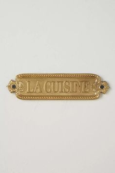 a gold plate with the word la cuisinee on it's front and side