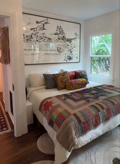 a bedroom with a large bed and artwork on the wall