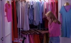 a woman looking at clothes in a closet