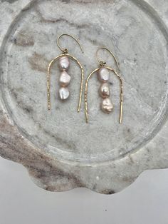 These elegant earrings guarantee to turn heads. The 14-K gold-filled wire, boasting a hammered finish, coupled with the distinctively shaped freshwater pearls, are designed to elevate any outfit with their sophisticated charm. We use 14k gold-filled high quality metal manufactured in the US and farm-raised freshwater pearls.  All of the jewelry is handmade in my little California studio. Elegant Earrings, Freshwater Pearls, Jewelry Earrings Dangle, Gold Filled, Dangle Drop Earrings, Dangle Earrings, Etsy Accessories, Jewelry Earrings, Accessory Gift