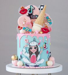 a birthday cake with an ice cream cone on top and decorations around the bottom tier