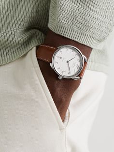 Our Senior Watches Editor, Mr Chris Hall, says that a dress watch should be simple, elegant and slim enough to sit beneath a shirt cuff, which is the case for Hermès Timepieces' 'Arceau' reference. Designed with a signature Barenia leather strap, it has a rounded 40mm polished stainless steel case that houses a herringbone-detailed dial with italicised Arabic numerals and a date window. The oscillating weight, on show through the exhibition case back, is stamped with the house's initial. We off… White Watches For Men, Laurent Ferrier, Hermes Watch, Titanium Watches, Latest Watches, Rubber Watches, Shirt Cuff, Mens Luxury, The Exhibition