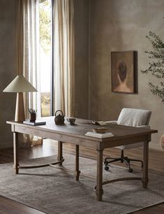 a wooden table sitting on top of a hard wood floor next to a lamp and window