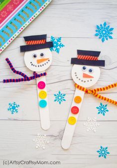 two snowmen made out of popsicle sticks