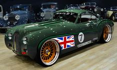 an old green car with the british flag painted on it's front wheel rims