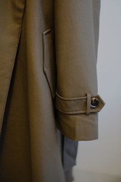 Experience timeless elegance and warmth with our meticulously designed brown trench coat. The oversized trench coat features a gracefully long silhouette, open front design, and matching belt for a tailored fit, this coat exudes sophistication while keeping you stylish and cozy during cooler seasons. Add a touch of modern minimalism to your look with this must-have outerwear piece. Khaki brown Long coat Belted Pockets Oversized fit Model is wearing a medium Timeless Outerwear With Belted Cuffs, Khaki Long Coat With Hidden Button Closure, Brown Gabardine Long Coat, Elegant Khaki Long Pea Coat, Elegant Long Khaki Pea Coat, Classic Khaki Outerwear With Belted Cuffs, Classic Oversized Outerwear With Belted Cuffs, Classic Khaki Belted Outerwear, Oversized Classic Brown Pea Coat