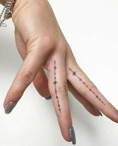 a woman's hand with stars tattooed on it