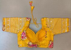 Beautiful yellow floral choli-cut saree blouse with embroidered sleeves. Buy designer blouse in USA from Pure Elegance. Disclaimer: The actual product may vary slightly from the image. These are custom orders, hence expect slight variation in color, placement of the motif or buta. ESTIMATED DELIVERYBecause this is a custom order, it would take about 4 weeks from the date of purchase. RETURN POLICY: This product is a custom order and cannot be returned or exchanged. Designer Yellow Choli With Floral Embroidery, Festive Yellow Top With Floral Embroidery, Festive Yellow Floral Embroidered Top, Festive Yellow Floral Embroidery Tops, Semi-stitched Yellow Choli With Floral Embroidery, Yellow Cutdana Blouse Piece For Navratri, Yellow Choli With Floral Embroidery For Festive Occasions, Festive Yellow Blouse With Floral Embroidery, Fitted Yellow Blouse For Festivals