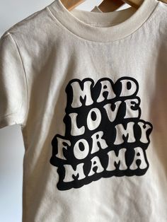 Mad Love for My Mama Tee Have a little who has mad love for their mama? This is the perfect tee for them! Not only great for Valentine's Day but can be worn year round! Bella Canvas unisex tee, natural color. 100% combed and wingspan cotton. Raised lettering. Offered in sizes 2T-5T Please allow 5-7 days max for production* Cute Organic Cotton Tops With Screen Print, Playful Crew Neck Top For Mother's Day, Mother's Day Cotton Tops With Lettering, Cute Organic Cotton Screen Print Tops, Cute Tops With Screen Print For Mother's Day, Short Sleeve Tops With Lettering For Mother's Day, Playful Tops With Funny Print For Mother's Day, Fun Graphic Print Top For Mother's Day, Family Matching Slogan Tops For Mother's Day