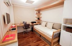 a small room with a bed, desk and computer on top of the desks