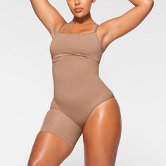 A perfect solution for outfits with an exposed left leg, this mid-waist and ultra-compressive short supports the tummy, waist, and thighs while enhancing and lifting your butt. Features an underband with interior silicone to prevent rolling and large round butt pockets. Fits true to size. | SKIMS Solution Short Left Leg Exposed (Bodysuit) | Medium Neutral | Seamless Sculpt Deep Plunge Bodysuit, Thigh Sculpting, Vintage Cami, Maternity Tights, Plunge Bodysuit, Belly Support, Mid Thigh Shorts, High Neck Bodysuit, Backless Bodysuit