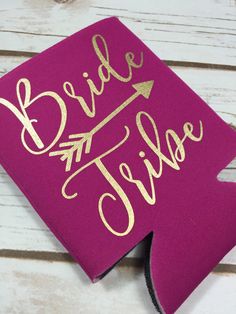 a pink and gold bride tribe flask with an arrow on the side that says bride tribe