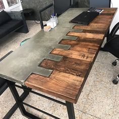 an office desk made out of wooden planks and metal legs with a laptop on top