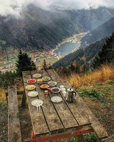 a picnic table with food on it in the mountains