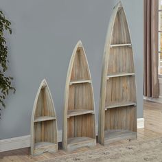 three canoe shaped bookshelves sitting next to each other