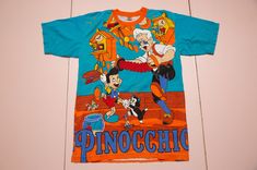 Vintage and rare PINOCCHIO aop all-over-print by Tony & Guy t-shirt. Made in Thailand. It is pre-used and in very good vintage condition. Size on label: Size fit men's M as medium. Please compare your measurements with the measurements provided below before buying this item.   Length from center back: 71 cm / 27.96" inches Chest: 50 cm / 19.69" inches Sleeve Length, from arm opening: 22 cm / 8.66" inches Shoulder to shoulder: 47 cm / 18.50" inches Material: 100% cotton. Condition: very good vint Vintage Cotton T-shirt With All Over Print, Graphic Tee With All Over Print For Fans, Vintage Short Sleeve T-shirt With All Over Print, Vintage All Over Print T-shirt For Streetwear, Vintage All-over Print T-shirt For Streetwear, Fan Merchandise Cotton T-shirt With All Over Print, Cotton T-shirt With Fan Merchandise Print, Cotton T-shirt With All Over Print For Fans, Retro Cotton T-shirt With All Over Print