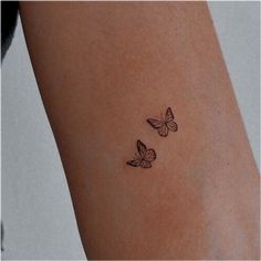 two butterflies tattoo on the left side of the right arm, and one is black