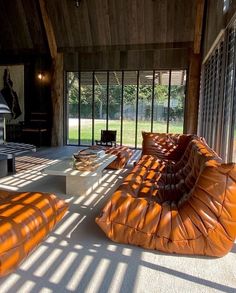 an orange couch sitting on top of a white floor next to a fire place in a living room